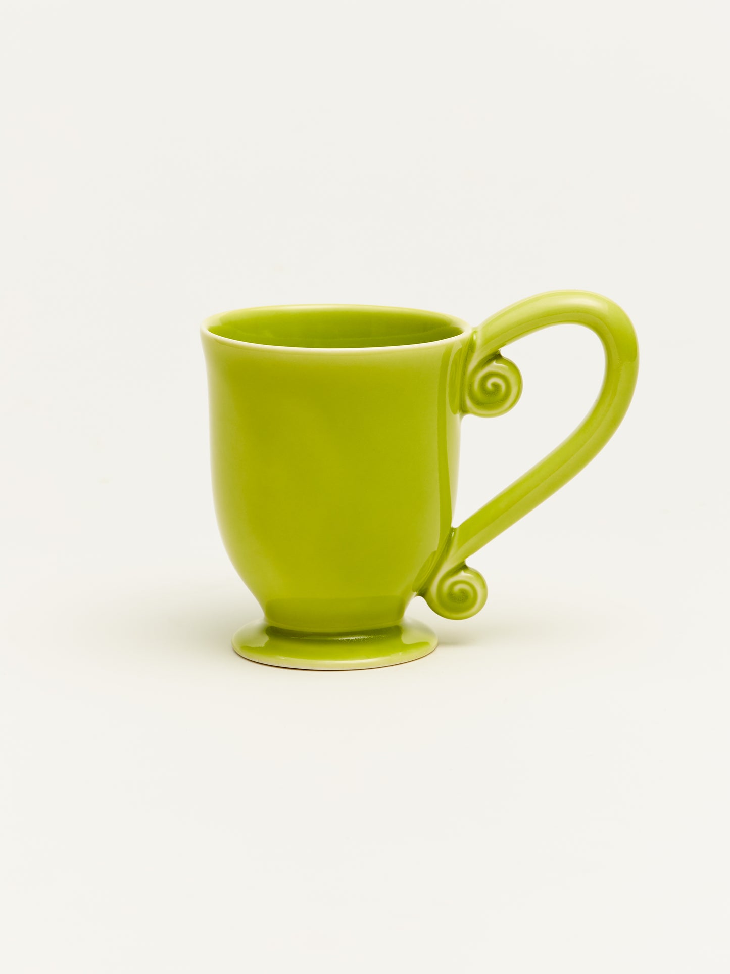 Handcrafted ceramic mug with a green swirl design, perfect for coffee or tea